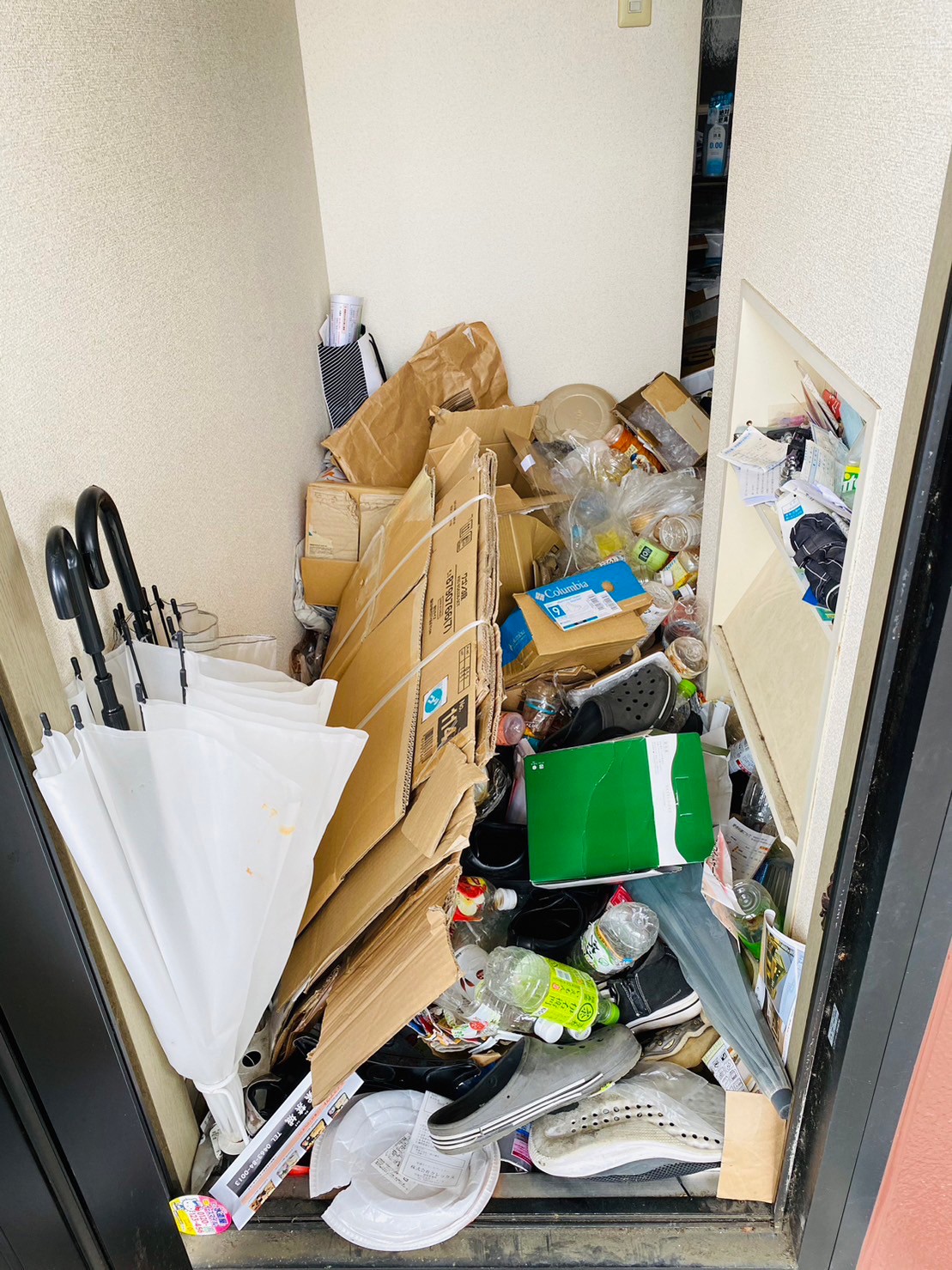 段ボール、壊れた傘、靴、ペットボトルなど家庭ゴミ1部屋分の回収前の状態