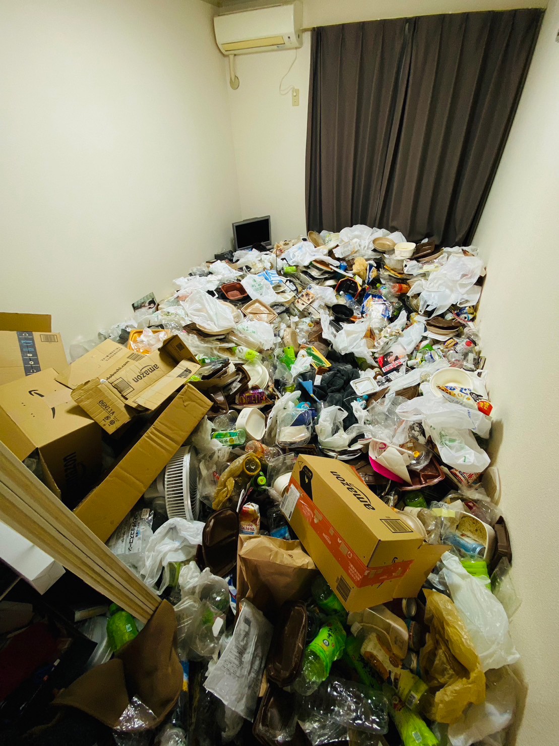 ペットボトル、段ボール、衣類、プラスチック容器など家庭ゴミ2部屋分の回収前の状態