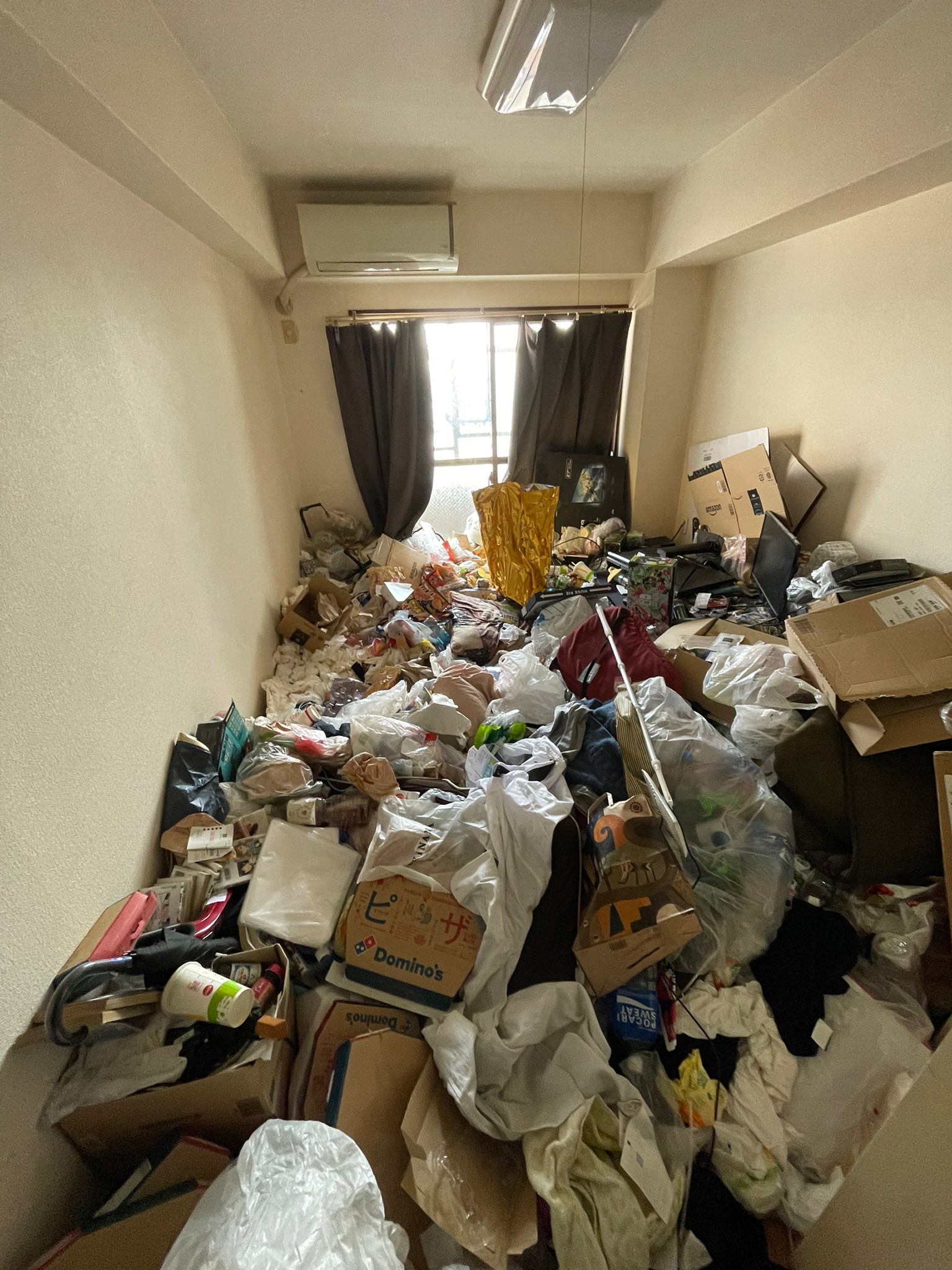 衣類、段ボール、傘、ペットボトルなど家庭ゴミ1部屋分の回収前の状態