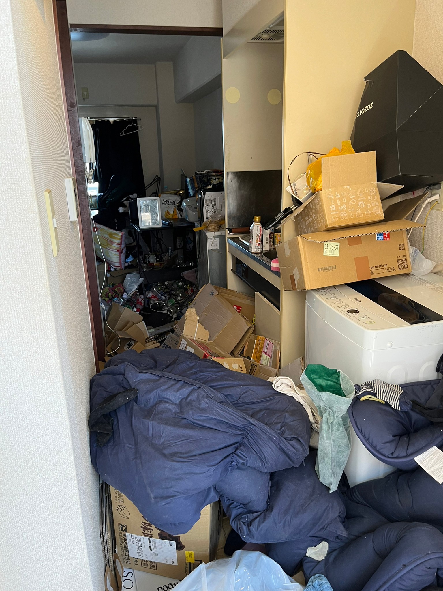 布団、クッション、段ボール、ペットボトルなど家庭ゴミ1部屋分の回収前の状態