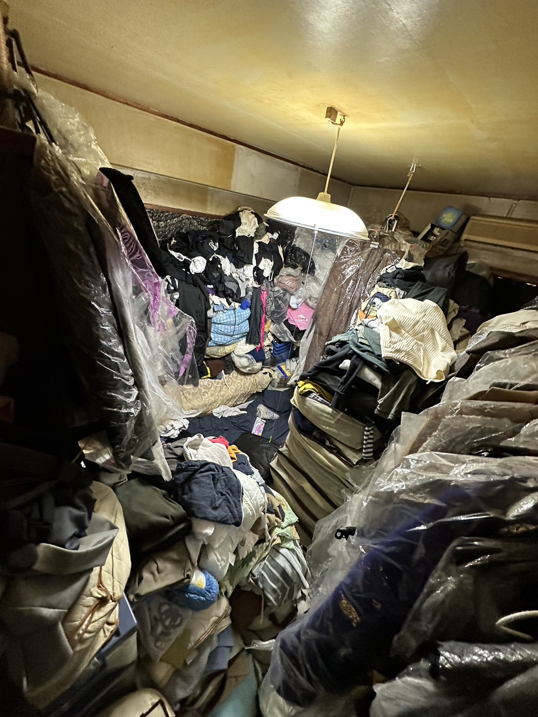 服、鞄、布団、衣装ケース、ハンガーラックなどの回収前の状態