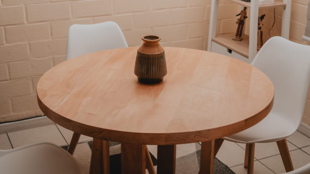 木製のテーブルと白い椅子の画像