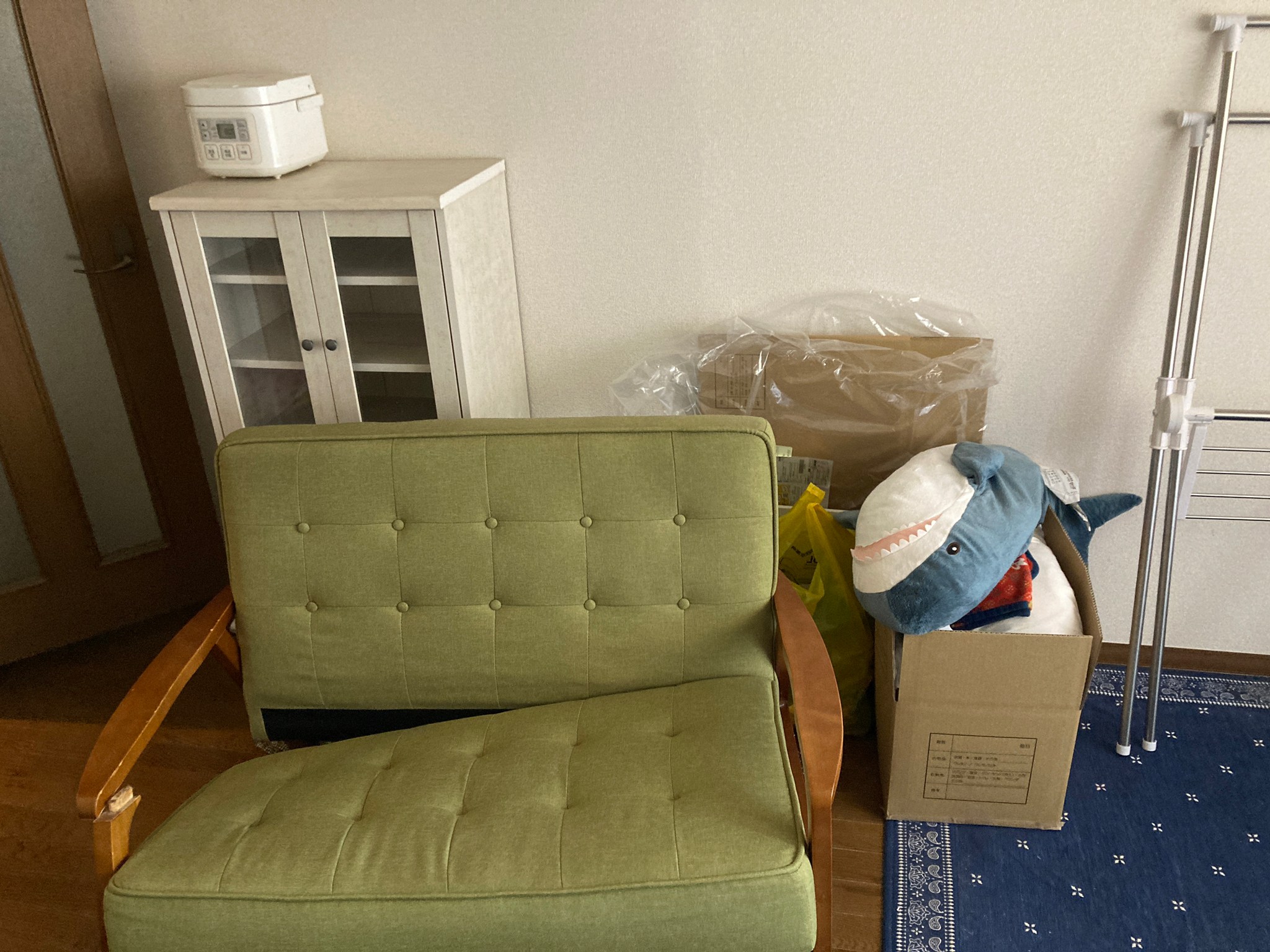 ソファー、棚、炊飯器、ぬいぐるみ、ラグ、物干しの回収前の状態