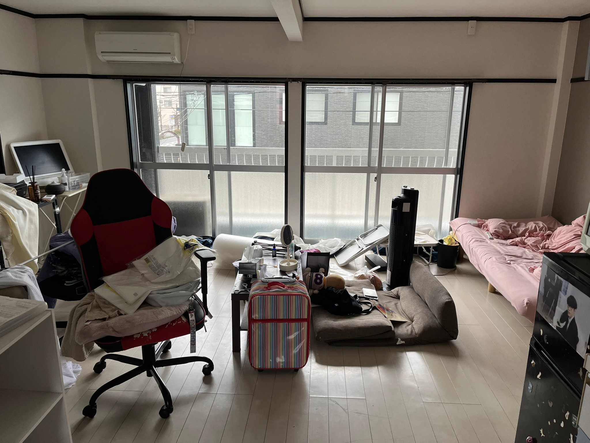 椅子、衣類、テーブル、ソファー、キャリーケース、パソコン、カラーボックス、冷蔵庫、ベッドの回収前の状態