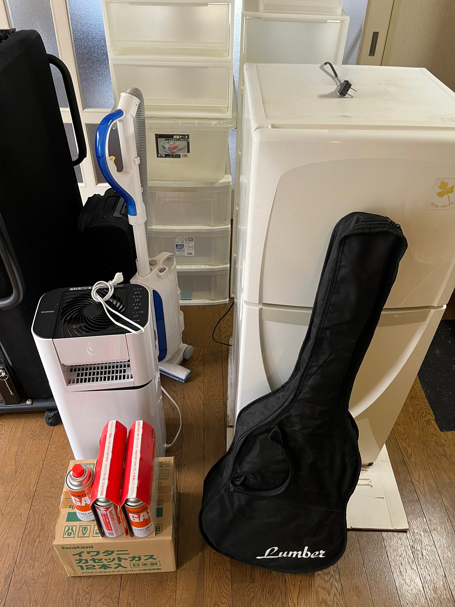 ギター、カセットコンロ用ガス、空気清浄機、掃除機、冷蔵庫、キャリーケースの回収前の状態