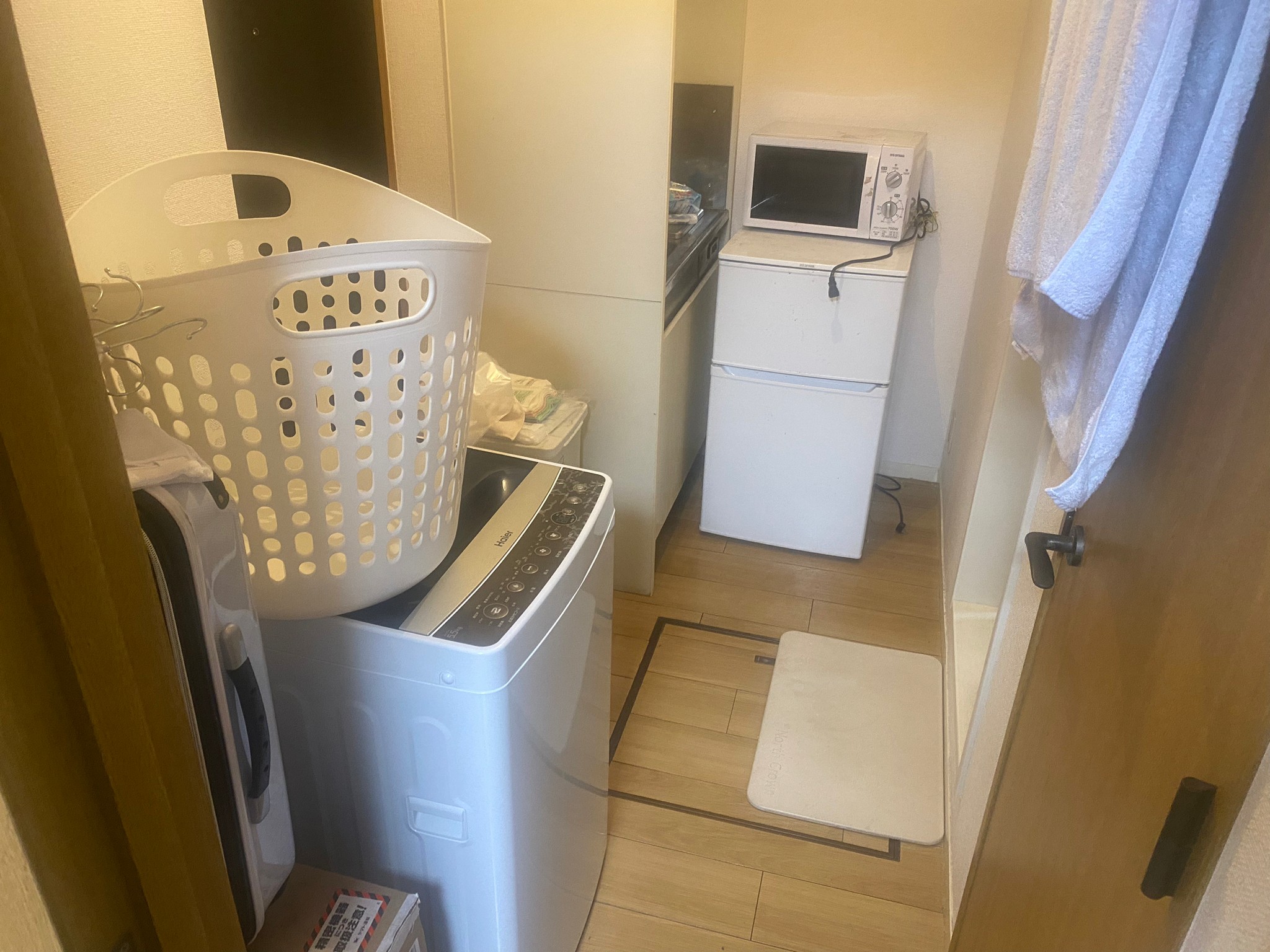 冷蔵庫、洗濯機、洗濯籠、電子レンジ、キャリーケースの回収前の状態