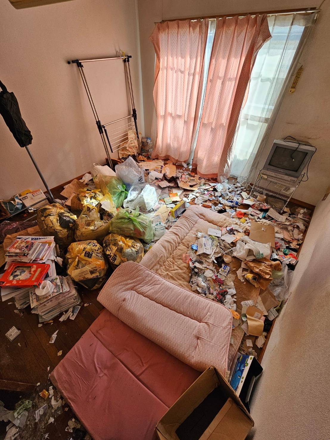 寝具、書籍、テレビ、生活ゴミなどの回収前の状態
