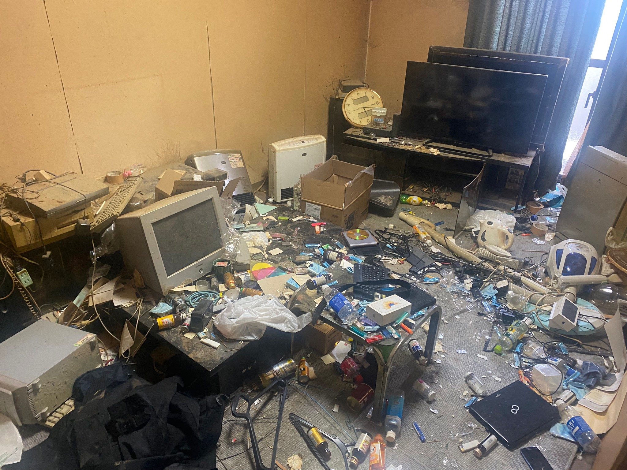 テーブル、テレビ、デスクトップパソコン、ノートパソコン、プリンター、ストーブ、生活ゴミの回収前の状態