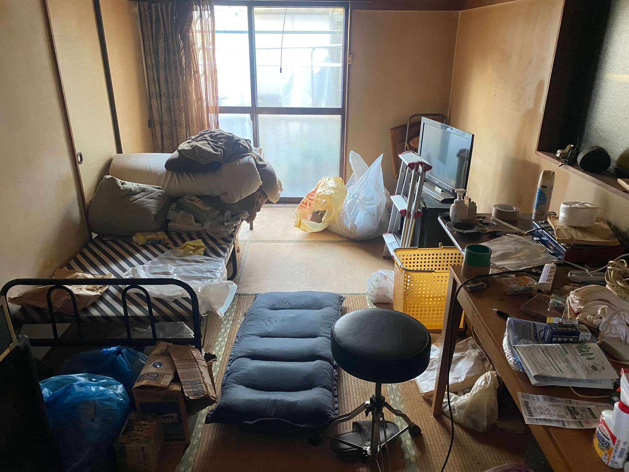 ベッド、布団一式、テレビ、テレビ台、テーブル、椅子、生活用品の回収前の状態