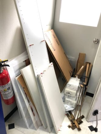 解体済みの木製家具、段ボール、小箱の束、金属製スタンドなどの回収前の状態