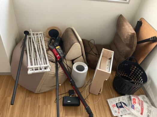 折りたたみローテーブル、ビーズクッション、座椅子、コードレス掃除機、物干しスタンド、カラーボックスなどの回収前の状態