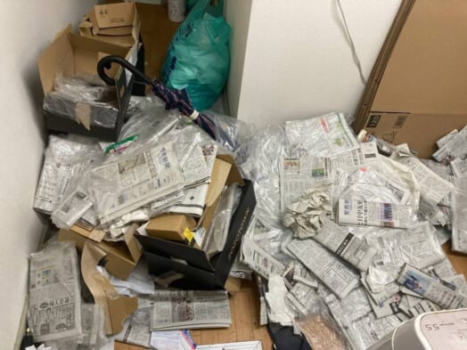 大量の通販段ボール、古新聞、生活ゴミの入った指定袋、不用な傘、生活雑貨などの回収前の状態