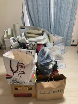 袋詰めの衣類・生活雑貨、紙袋、箱類、クッション、小型家財などの回収前の状態